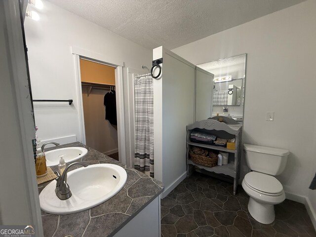312 Schuman Dr, Bloomingdale, GA 31302 - full bath with curtained shower, toilet, vanity, a textured ceiling, and a walk in closet