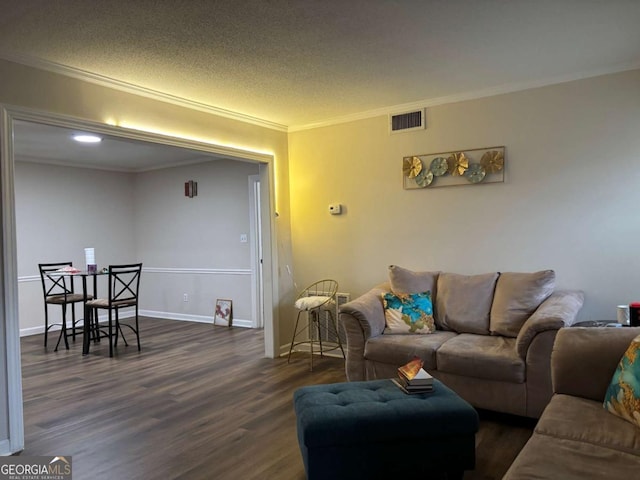 living room with a textured ceiling, visible vents, baseboards, ornamental molding, and dark wood-style floors