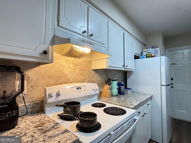 kitchen with under cabinet range hood, white electric stove, white cabinets, and decorative backsplash