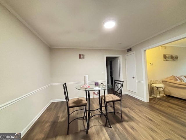 dining area featuring baseboards, crown molding, visible vents, and wood finished floors