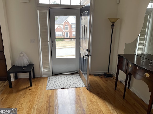 foyer with light wood-style flooring and baseboards