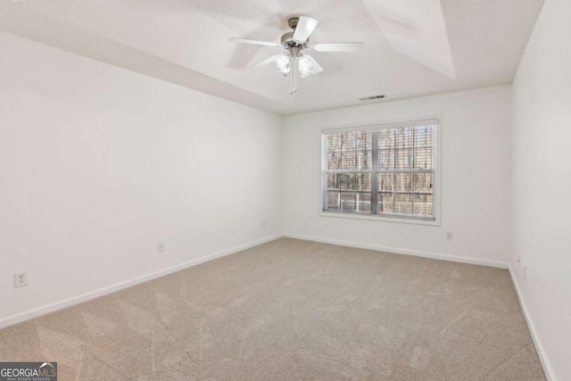 spare room featuring light carpet, baseboards, visible vents, and a ceiling fan