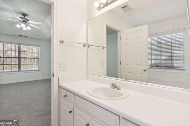 bathroom featuring ceiling fan, vanity, visible vents, and baseboards