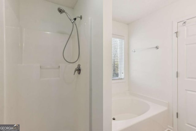 bathroom featuring a washtub and walk in shower