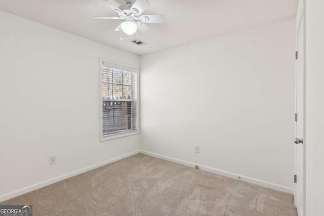 unfurnished room featuring light carpet, baseboards, visible vents, and a ceiling fan