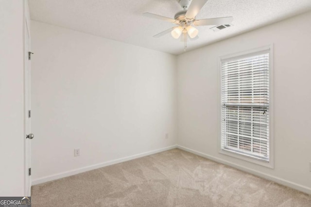 unfurnished room featuring ceiling fan, baseboards, a textured ceiling, and light colored carpet