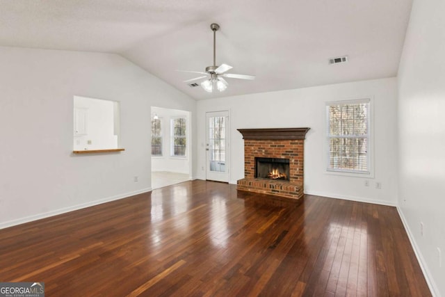 unfurnished living room with a healthy amount of sunlight, a fireplace, visible vents, and dark wood finished floors