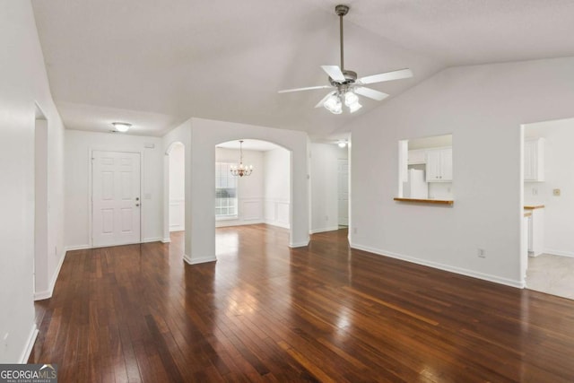 unfurnished living room featuring arched walkways, lofted ceiling, dark wood-type flooring, baseboards, and ceiling fan with notable chandelier