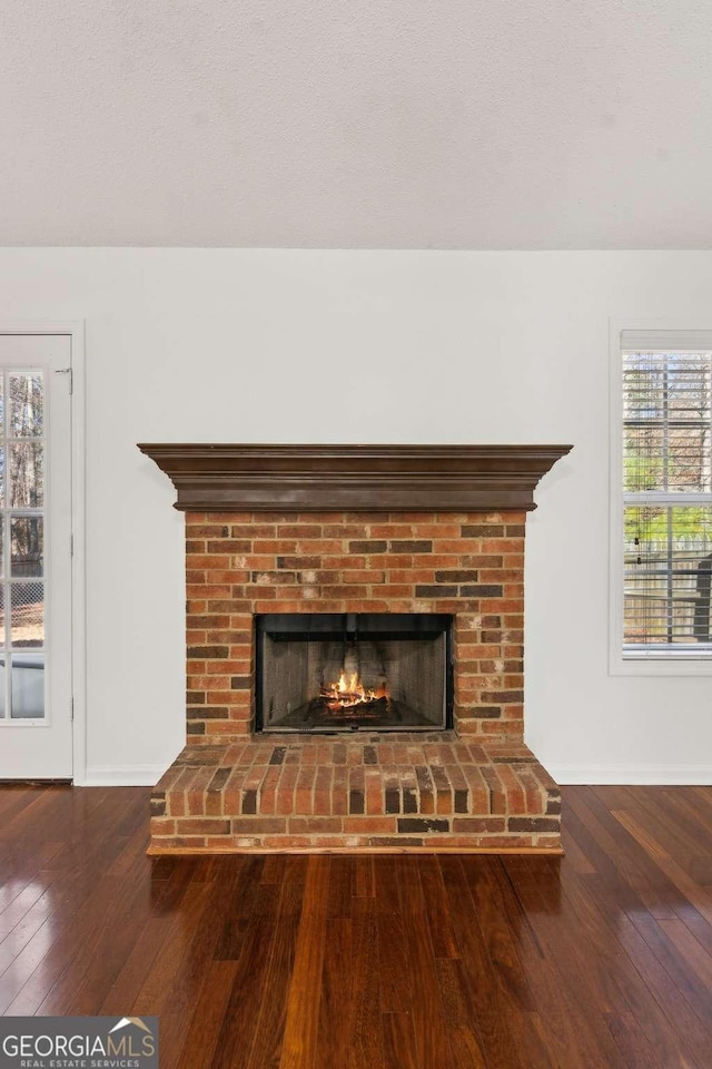 interior details with a fireplace, baseboards, and wood finished floors