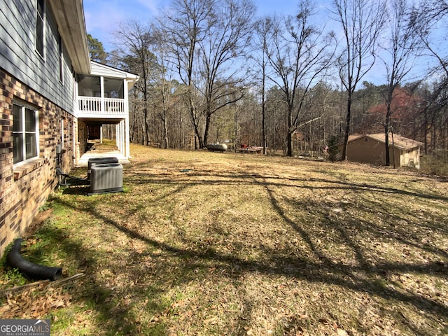 view of yard featuring central AC unit and a sunroom