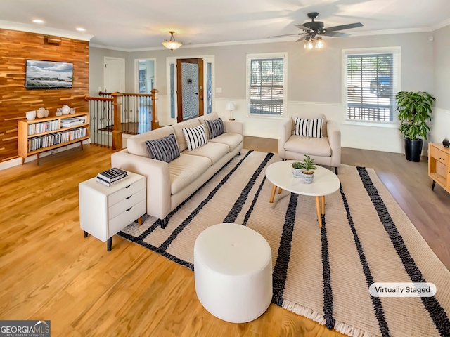 living room with wood walls, recessed lighting, crown molding, and wood finished floors