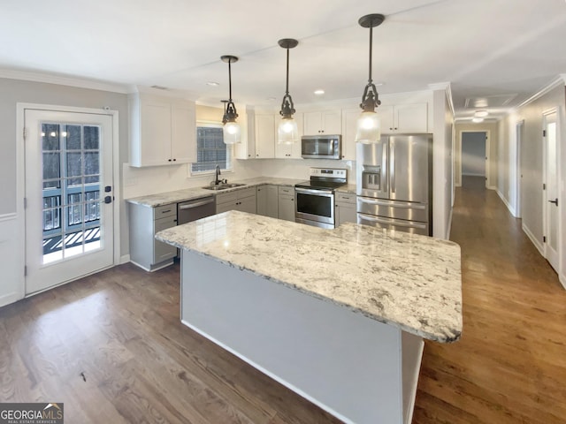 kitchen featuring appliances with stainless steel finishes, dark wood-type flooring, light stone counters, and ornamental molding