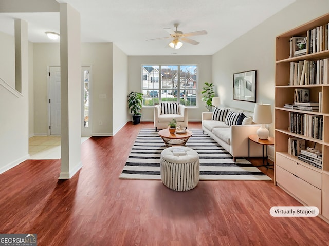 living area with a ceiling fan, baseboards, and wood finished floors