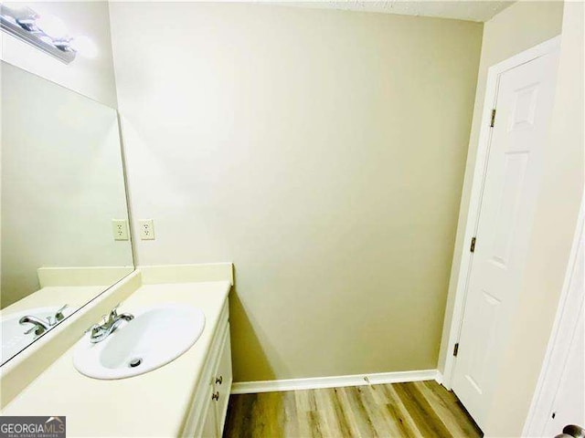 bathroom featuring vanity, baseboards, and wood finished floors