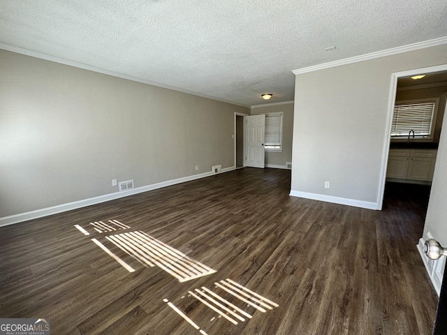 interior space featuring dark wood-style floors, a textured ceiling, baseboards, and crown molding