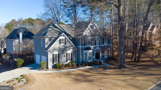 view of front of home with a garage, a balcony, a front lawn, and concrete driveway