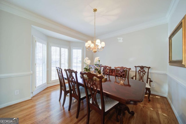 dining area featuring light wood finished floors, baseboards, ornamental molding, and a chandelier