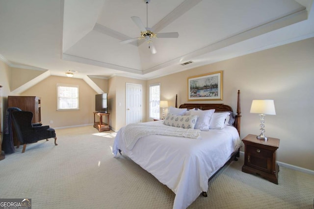 carpeted bedroom with a ceiling fan, visible vents, baseboards, a tray ceiling, and crown molding