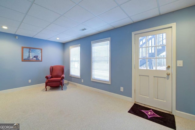 sitting room with carpet floors, a drop ceiling, and baseboards