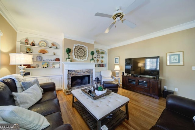 living room with light wood-style floors, crown molding, and a ceiling fan