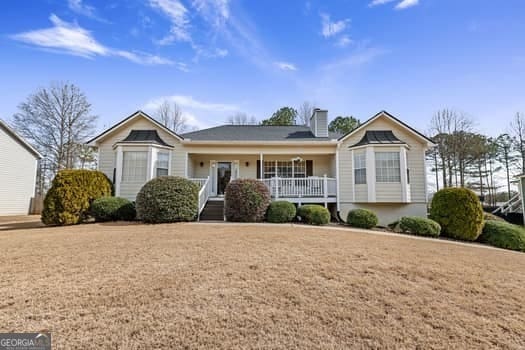 ranch-style house featuring a porch and a chimney