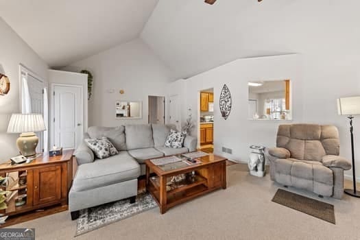 living room featuring light carpet and vaulted ceiling