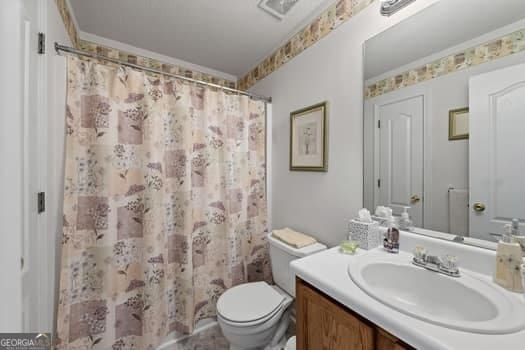 full bathroom with toilet, ornamental molding, vanity, and a shower with curtain