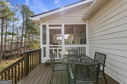 deck featuring outdoor dining area and a sunroom