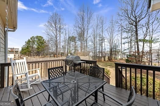 deck featuring outdoor dining space and grilling area