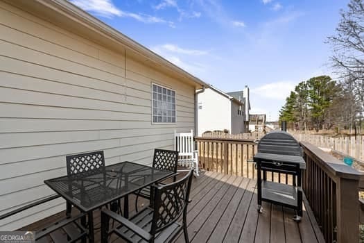 wooden terrace with outdoor dining space and area for grilling