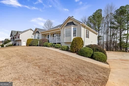 view of front facade with a porch, driveway, and a front lawn