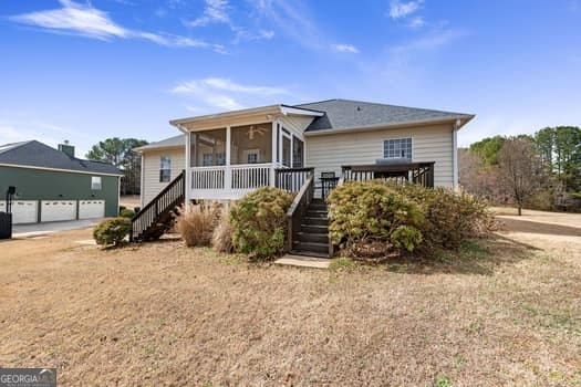 view of front of home with a garage, a sunroom, and stairs