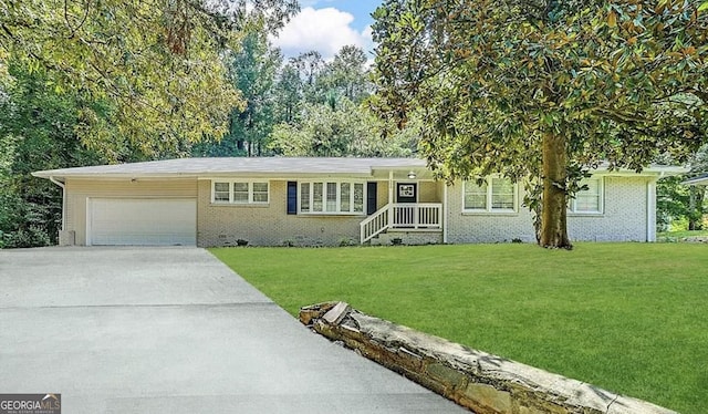 single story home with a garage, concrete driveway, a front lawn, and brick siding