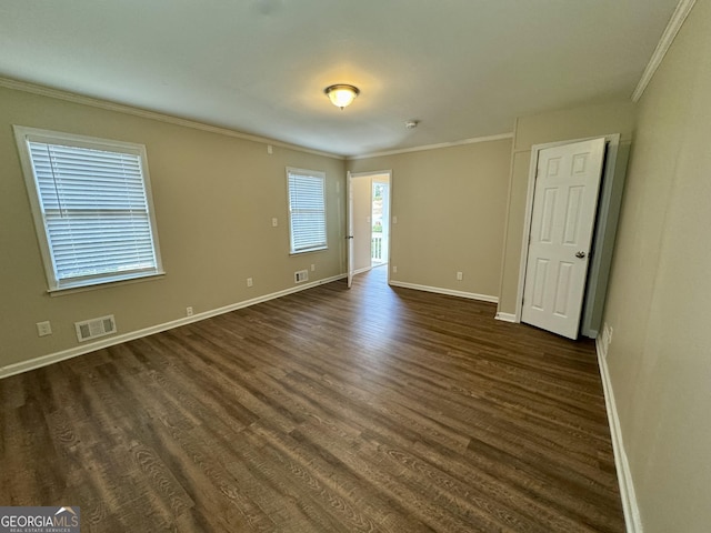 unfurnished bedroom featuring baseboards, visible vents, dark wood-type flooring, and ornamental molding