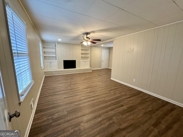 2430 Fern Valley Ct, East Point, GA 30344 - unfurnished living room featuring ceiling fan, a fireplace, dark wood-style flooring, built in features, and wood walls