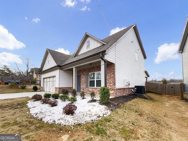 view of side of property with a garage, brick siding, board and batten siding, and fence