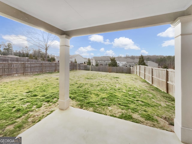 view of yard featuring a patio area, a fenced backyard, and a residential view