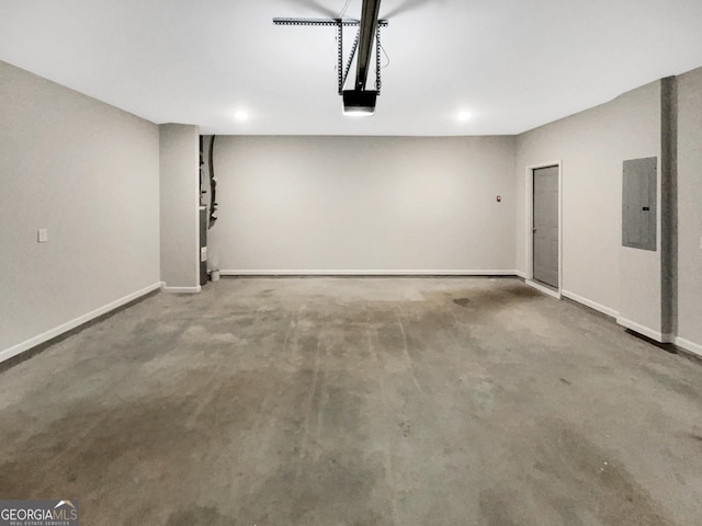 garage featuring electric panel, baseboards, and a garage door opener