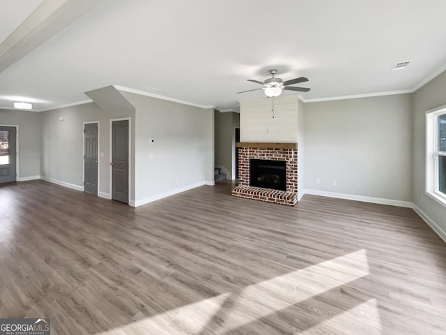 unfurnished living room featuring visible vents, a fireplace, baseboards, and wood finished floors