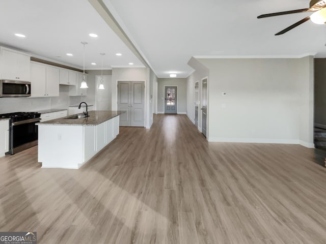 kitchen featuring light wood-style floors, white cabinetry, stainless steel appliances, and open floor plan