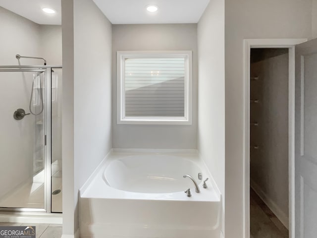 full bathroom featuring a stall shower and a garden tub