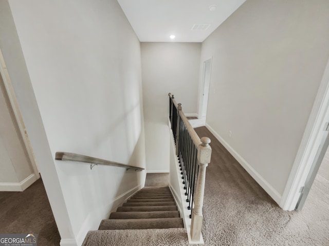 staircase with carpet floors, visible vents, and baseboards