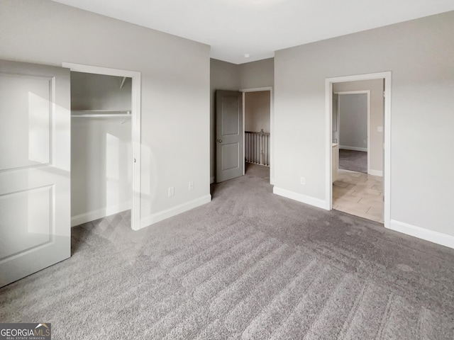 unfurnished bedroom with a closet, carpet, and baseboards