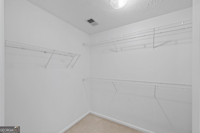 spacious closet featuring light carpet and visible vents