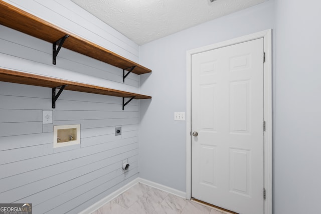 washroom featuring a textured ceiling, hookup for an electric dryer, laundry area, washer hookup, and marble finish floor