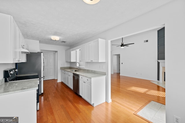 kitchen with appliances with stainless steel finishes, a sink, and white cabinets