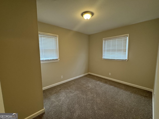 carpeted spare room with baseboards