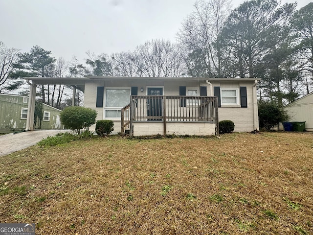 view of front of home with driveway, brick siding, and a front yard