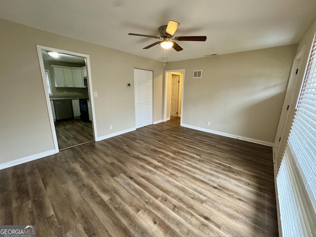 unfurnished bedroom with dark wood-style flooring, visible vents, ensuite bath, and baseboards