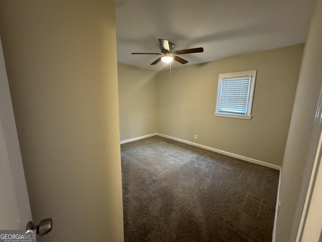 carpeted empty room with ceiling fan and baseboards